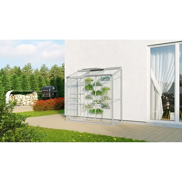 Vitavia Gewächshaus Styx 1300 - Außenmaß inkl. Dachüberstand (B x T): 192,8 x 69 cm, 3 mm, Aluminium - Ein Gewächshaus mit einem silbernen Rahmen an der Seite eines Hauses. Es ist mit Pflanzen gefüllt und hat ein Fenster in der Nähe.