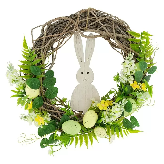 Dekokranz Osterhase - Durchmesser: 38 cm - Ein Osterkranz aus geflochtenen Zweigen, dekoriert mit grünen Blättern, weißen und gelben Blumen, gesprenkelten Eiern und einem weißen Holzhasen.