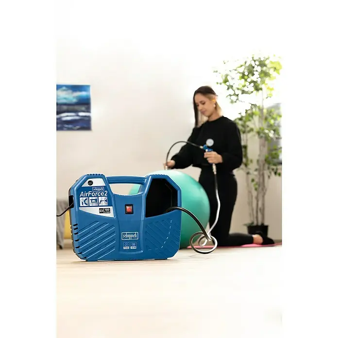 Scheppach Kompressor Air Force 2 - 1.100 W, Max. Druck: 8 bar - Die Scheppach AirForce2 im Einsatz: Eine Frau pumpt einen Gymnastikball mit dem blauen, handlichen Kompressor auf. Praktisch und effizient!