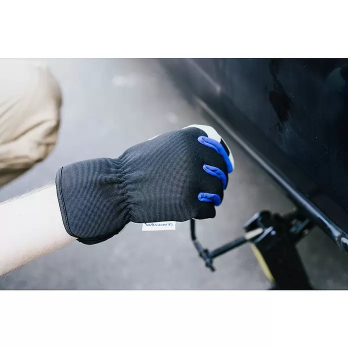 Wisent Arbeitshandschuhe - Handschuhgröße: 8, Grau/Schwarz - Schwarzer Wisent Arbeitshandschuh mit blauen Fingerspitzen und Netzstoff an einer Hand, die einen Wagenheber bedient.