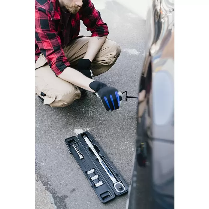 Wisent Arbeitshandschuhe - Handschuhgröße: 8, Grau/Schwarz - Person benutzt Drehmomentschlüssel zum Festziehen einer Radmutter am Auto, mit Chrom-Drehmomentschlüssel-Set und Nüssen in der Kassette auf Asphalt.