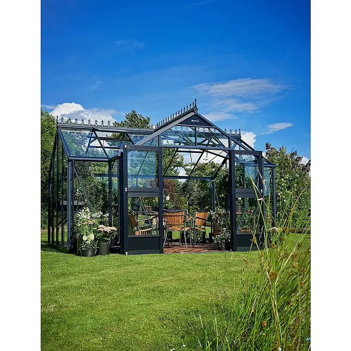 Juliana Gewächshaus Orangerie - Außenmaß inkl. Dachüberstand (B x T): 439 x 296 cm, Material Seitenwand: Glas, 3 mm, Anthrazit - Ein elegantes Gewächshaus mit geöffneten Türen, umgeben von üppigem Grün und einem klaren, blauen Himmel.