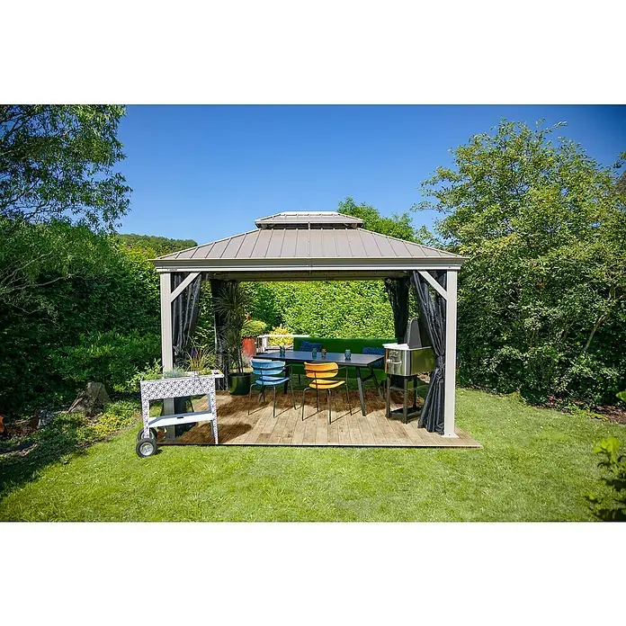 Sojag Standard-Pavillon Messina 10 x 12 - B x T: 363 x 298 cm, Farbe Gestell: Taupe, Aluminium - Das Bild zeigt einen Pavillon mit Grill, Tisch und Stühlen auf einer Holzterrasse im Garten.