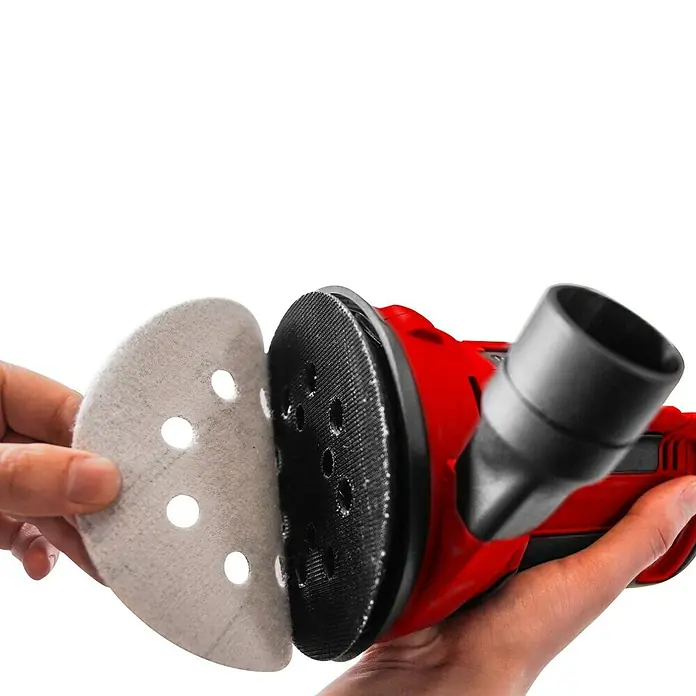 Einhell PXC 18V Lijadora excéntrica de batería TE-RS 18 Li-Solo -  - Detalle de una lijadora orbital roja con papel de lija que se está aplicando. La herramienta está diseñada para trabajos de lijado fino.