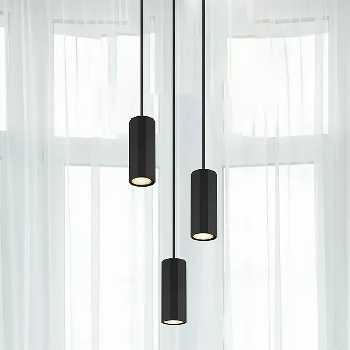Globo James Pendelleuchte - 25 W, Ø x H: 20 x 120 cm, Schwarz matt - Elegante schwarze Pendelleuchten mit zylindrischem Design setzen moderne Akzente vor einem hellen Fenster.