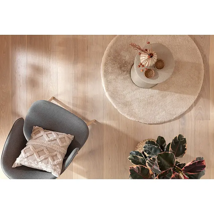 Fellteppich Happy - Beige, Durchmesser: 120 cm, 100 % Polyester (Flor) - Eine stilvolle Einrichtung mit einem grauen Sessel, einem runden Teppich und einem kleinen Tisch mit Dekoration.