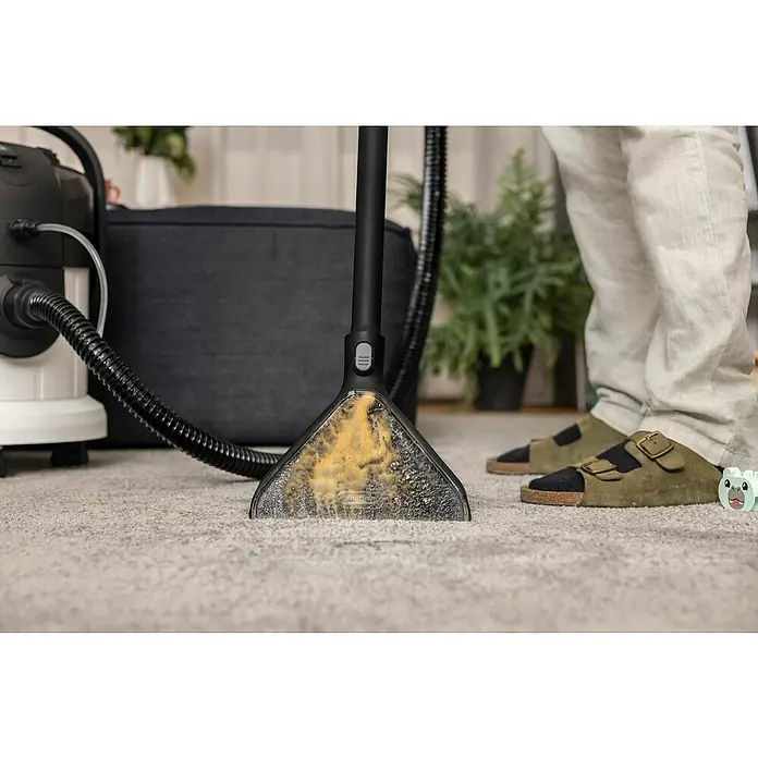 Kärcher Elektro-Nass- & Trockensauger SE4PLUS - 1.000 W, Behältervolumen: 4 l - Nahaufnahme eines tragbaren Fleckenreinigers, der einen Teppich reinigt und Schmutz und Flecken entfernt. Ideal für die schnelle Reinigung zu Hause.