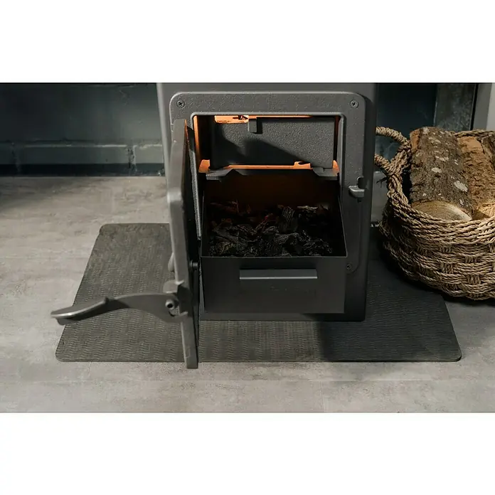 Werkstattofen Thalia - 5,3 kW, Raumheizvermögen: 160 m³, Schwarz - Nahaufnahme eines Holzofens mit geöffneter Tür, der Holzkohle enthält und neben einem Korb mit Holz steht.
