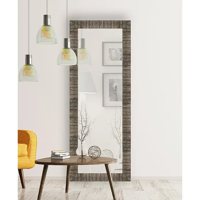 Espejo con marco Fantasía - 56 x 136 cm, Colores surtidos, Materiales naturales - Un elegante espejo rectangular con un marco estampado apoyado contra una pared blanca, creando un ambiente moderno.