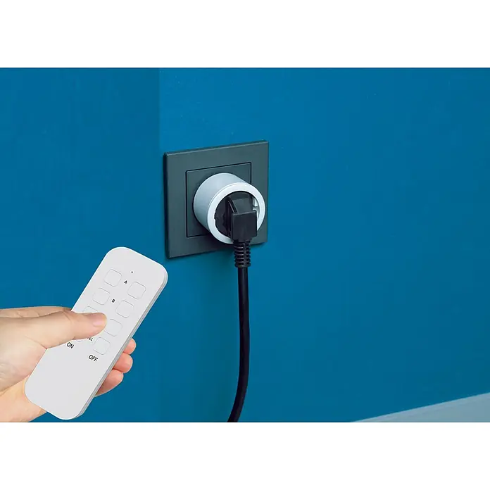 Intertek Funksteckdosen-Set mit Fernbedienung - Weiß, 3 Stk. - Intelligente Steckdose mit Fernbedienung an einer blauen Wand. Mit der Steckdose können Sie Geräte fernsteuern.