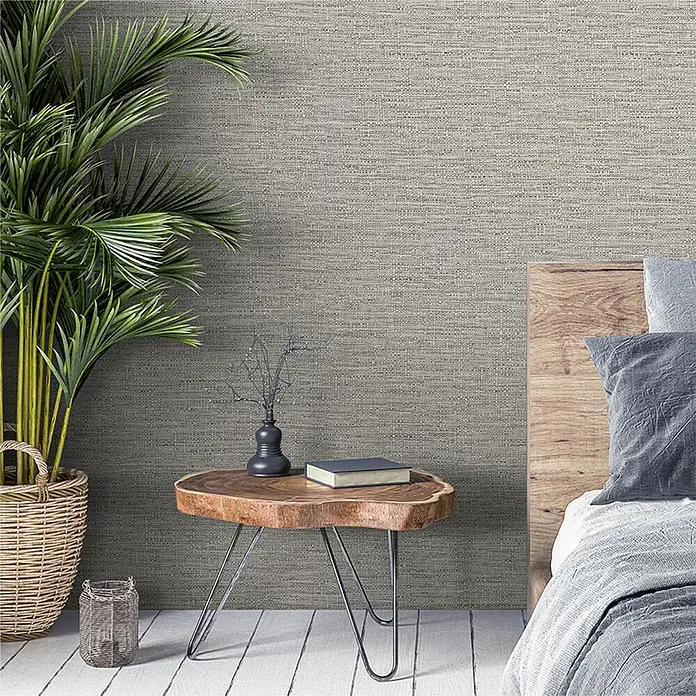 Papel pintado Liso texturado - Gris, 10 x 0,53 m - Primer plano de una mesita de noche rústica de madera con decoraciones minimalistas, complementada con una planta de interior y una pared estampada con textura.