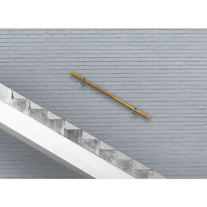 Treba Frewa Handlauf-Set H22 - Eiche, Versiegelt, Länge: 1.500 mm, Kugelringhalter Edelstahloptik - Holzgeländer an einer grauen Ziegelwand neben einer Betontreppe. Das Geländer wird durch elegante Metallhalterungen befestigt.