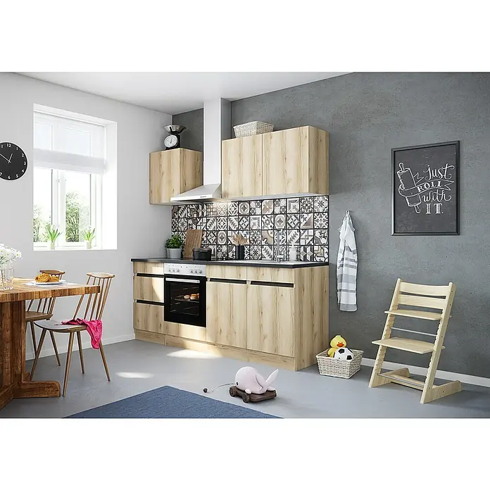 Optifit Singleküche Kaya - Breite: 210 cm, Wildeiche Nachbildung, Farbe Dunstabzugshaube: Silber, Mit Elektrogeräten - Helle Küche mit Holzschränken, Arbeitsplatte in Schwarz, Fliesenwand und Holztisch mit Stühlen im Essbereich. Dekorative Elemente machen es wohnlich.