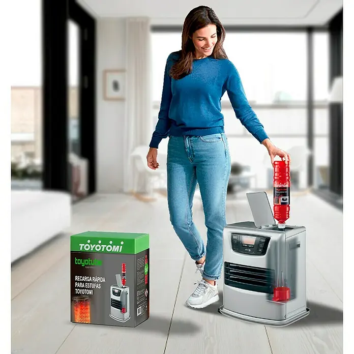 Toyotomi Parafina Toyotube - 1,4 l, 6 ud. - Mujer recarga una estufa Toyotomi con combustible de una botella roja, con el embalaje del producto al lado.
