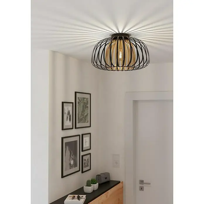 Eglo Encinitos Plafón redondo - 40 W, Ø x Al: 45 x 26 cm, Negro/Oro, E27 - Primer plano de una moderna lámpara de techo de madera y metal, que emite un brillo cálido en una habitación elegante.