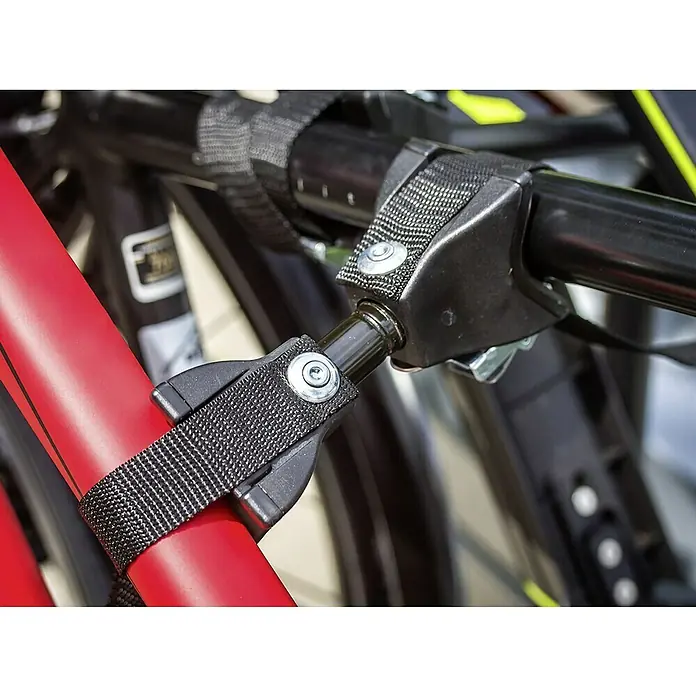 Eufab Fahrradträger Amber III - Geeignet für: 3 Fahrräder, Passend für: Fahrzeuge mit Anhängerkupplung - Nahaufnahme eines Fahrradträgers, der ein rotes Fahrrad mit Gurten und Metallschnallen sichert.