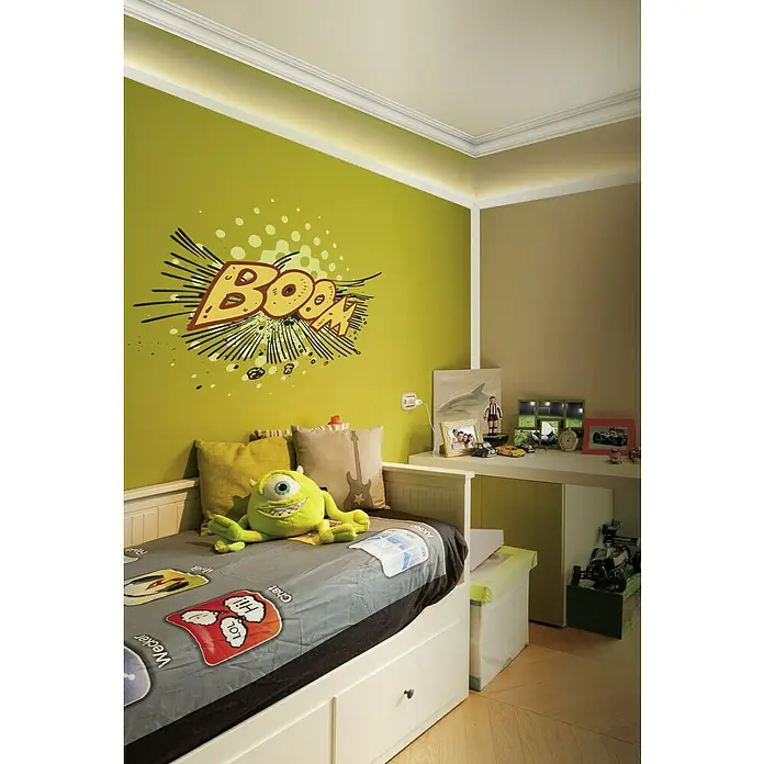 Zierprofil E 24 - 200 cm x 70 mm x 7 cm, XPS-Hartschaumplatten - Ein Kinderzimmer mit einem Bett, einem grünen Monsterkuscheltier und einem Wandbild mit der Aufschrift "BOOM!".
