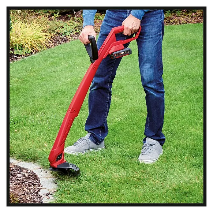 Einhell Power X-Change 18V Akku-Rasentrimmer GC-CT 18/24 Li P - 18 V, 1,5 Ah, Li-Ionen, 1 Akku - Eine Person benutzt einen roten Akku-Rasenkantenschneider, um die Rasenkante zu trimmen.