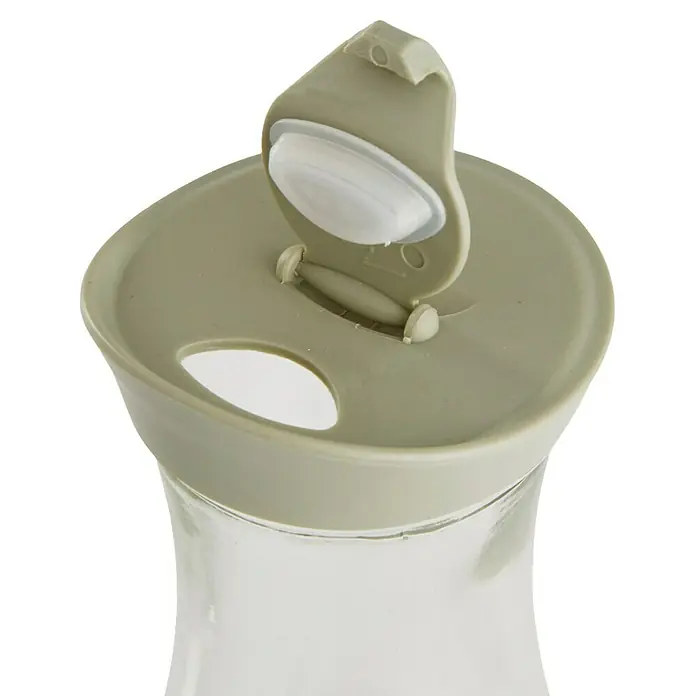 Jarra con tapa - Vidrio, Arena natural/Verde musgo/Amarillo arena, 1 ud. - Primer plano de una jarra de vidrio con una tapa gris abierta que revela un tapón blanco.