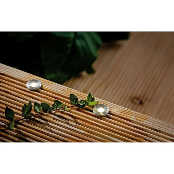 Paulmann Plug & Shine Set básico Micro Pen II - 0,22 W, Número de bombillas: 5 ud., Plata, 5 ud. - Focos empotrados en una terraza de madera con hojas. Los focos son pequeños, redondos y emiten una luz blanca cálida.