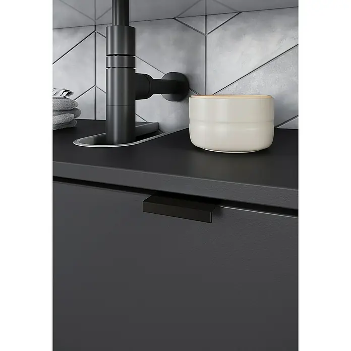 Germania Arcena Waschtischunterschrank - B x T x H: 60 x 34 x 56 cm, Graphit, Matt - Detailaufnahme eines modernen Badezimmers mit schwarzem Wasserhahn, Seifenspender und Schubladenfront mit Griffleiste.