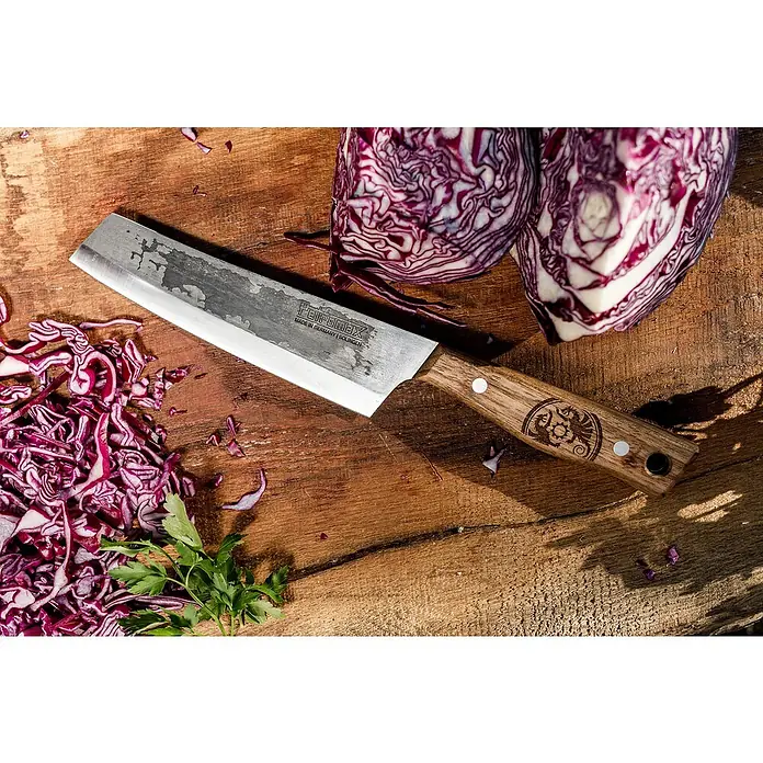 Petromax Küchenmesser - Stahl, 31,5 cm - Nahaufnahme eines Teiromax Messers neben gehacktem Rotkohl und ganzen Kohlhälften auf einem Holztisch.