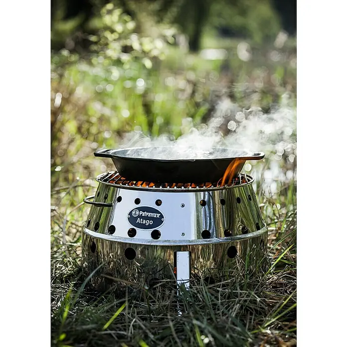 Petromax Grillpfanne - Durchmesser: 25,1 cm - 30 cm, Gusseisen - Der Petromax Atago in Aktion beim Kochen im Freien. Ein vielseitiger Kocher, Grill und Feuerstelle für Outdoor-Abenteuer mit Topf und Rauch.