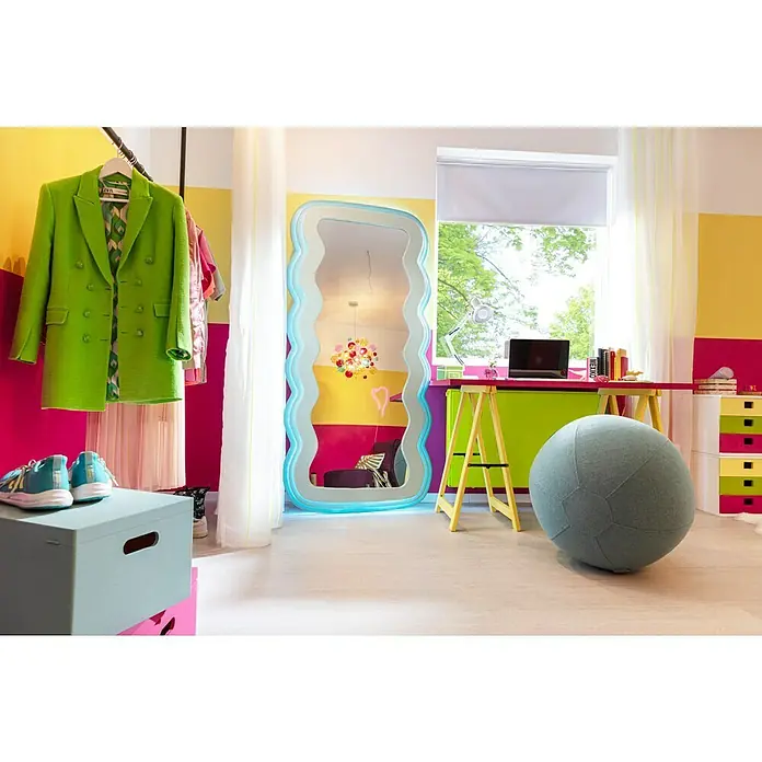 Expo Ambiente Rollo Mini - B x H: 120 x 150 cm, Weiß, Uni, Verdunkelnd - Ein Spiegel mit gewelltem Rahmen steht in einem farbenfrohen Zimmer, das mit einem Schreibtisch, einem Stuhl und Kleidung ausgestattet ist.