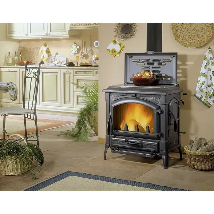La Nordica Kaminofen Isotta Evo - 14,5 kW, Mit Kochplatte, Raumheizvermögen: 338 m³, Material Verkleidung: Stahl, Schwarz - Küchenansicht mit einem eleganten, gusseisernen Holzofen, der Wärme und Stil in den Raum bringt. Der Ofen ist ein echter Hingucker.