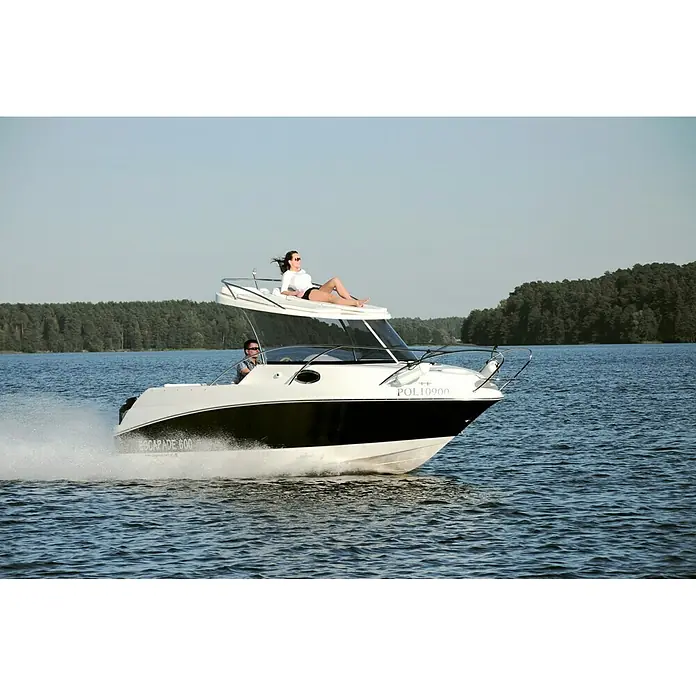 PEGAZUS GFK-Boot Escapade 600 Suntop Ready to Go 150 - Motorleistung: 110 kW, Geeignet für: Max. 6 Personen, Norm: CE-Klasse C - Das Foto zeigt ein gleitendes Motorboot auf einem See mit zwei Personen an Bord, eine Frau liegt auf dem Dach.