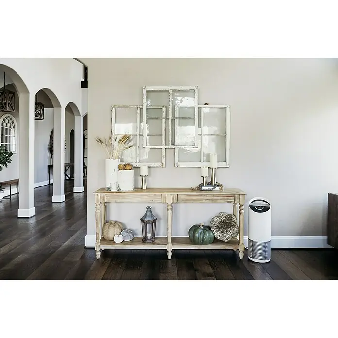Leitz TruSens Luftreiniger Z-3000Raumgröße: 0 m² - 70 m², SensorPod Luftqualitätsmesser - Elegantes Interieur mit einem modernen Luftreiniger, der neben einem dekorierten Konsolentisch mit Herbstmotiven steht.