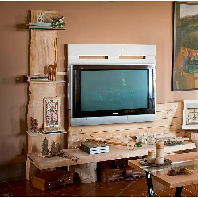 Tablero de madera maciza Tarugo - Abeto rojo, L x An x Es: 200 cm x 50 cm x 50 mm, Anchura resultante: 40 cm - 48 cm - Primer plano de un mueble de TV rústico de madera con un televisor Panasonic, libros, decoraciones y una mesa de madera delante.