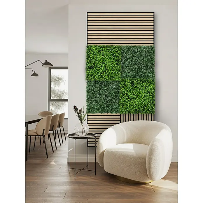Jangal Wandpaneel Flora - Dark Green Design Buxus, 520 x 520 x 22 mm - Das Bild zeigt eine grüne Wandpaneele mit Holzdetails in einem modernen Wohnraum, ergänzt durch einen eleganten Sessel und Beistelltisch.