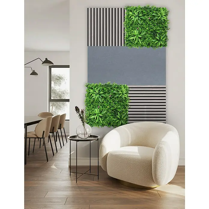 Jangal Akustikpaneel Modular Wall Furnier - Oulanka Oak, 520 x 520 x 10 mm - Eine Wandgestaltung mit grünen Pflanzen-Panels, Holzlatten und einer grauen Fläche, die einen modernen Sessel und Beistelltisch ergänzt.