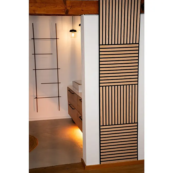 Jangal Akustikpaneel Modular Wall Furnier - Fanal Oak, 520 x 520 x 10 mm - Ein dekoratives Wandpaneel mit hellen Holzlatten und schwarzen Akzenten, das einem Raum Struktur und Wärme verleiht.