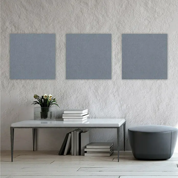 Jangal Wandpaneel Modular Wall PET Filz - Grey, 520 x 520 x 6 mm - Wohnzimmer-Szene mit drei grauen Wandkunstwerken über einer weißen Konsole mit Dekorationen und einem grauen Hocker.