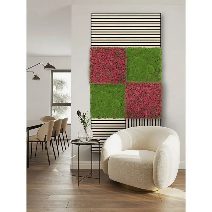 Jangal Wandpaneel Modular Wall Moos - Forest Green Bulk, 520 x 520 x 30 mm - Wandbild mit Moosquadraten in Grün und Pink, gerahmt von Holzlatten, neben einem Sessel und einem Tisch.