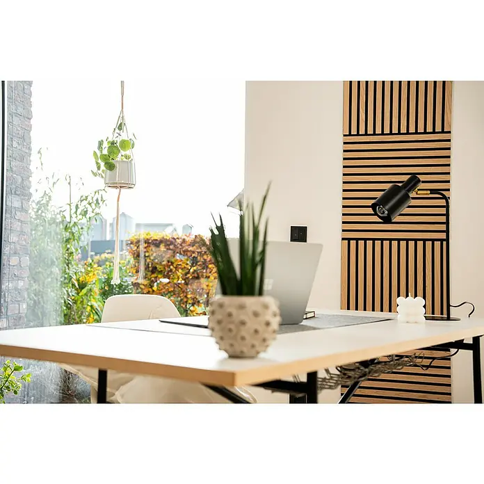 Jangal Akustikpaneel Modular Wall Furnier - Fanal Oak, 520 x 520 x 10 mm - Ein moderner Arbeitsplatz mit einem weißen Schreibtisch, einer stilvollen Lampe und einer Akustikwand. Die Zimmerpflanzen bringen einen Hauch Natur ins Büro.