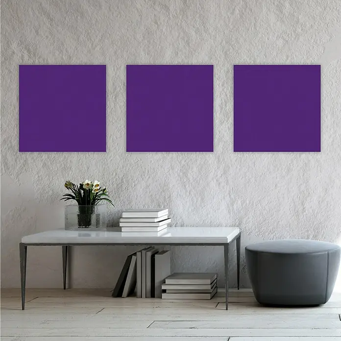 Jangal Wandpaneel Modular Wall PET Filz - Violet, 520 x 520 x 6 mm - Wand mit drei violetten Bildern, einem Tisch mit Büchern und Blumen sowie einem grauen Hocker.