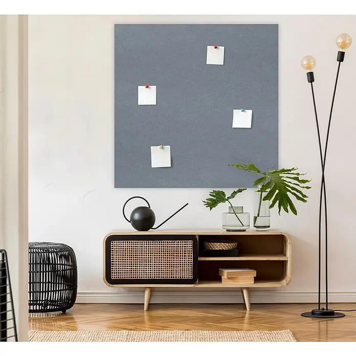 Jangal Wandpaneel Modular Wall PET Filz - Grey, 1.040 x 520 x 6 mm - Ein graues Memoboard mit Zetteln hängt über einem Holzschrank, dekoriert mit Pflanzen und einer Lampe, und schafft eine stilvolle, organisierte Atmosphäre.