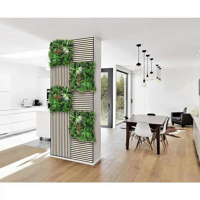 Jangal Wandpaneel Flora - Exotic Mixed Flora, 520 x 520 x 50 mm - Das Bild zeigt ein modernes Interieur mit einer dekorativen Wand aus Holzlatten und grünen Pflanzenquadraten als Raumteiler.