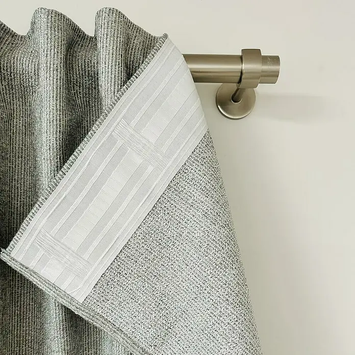Cortinas pasabarra Muka - An x Al: 140 x 260 cm, Gris, Materiales naturales - Primer plano de un panel de cortina gris con una banda de refuerzo blanca y una barra de cortina de metal contra una pared blanca.
