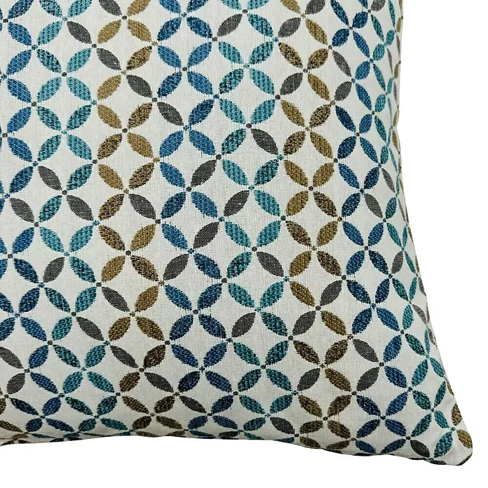 Cojín Yunus - 45 x 45 cm, Textil, Azul, Cuadrado - Primer plano de un cojín decorativo con un estampado floral en tonos de azul, marrón y gris sobre un fondo blanco.