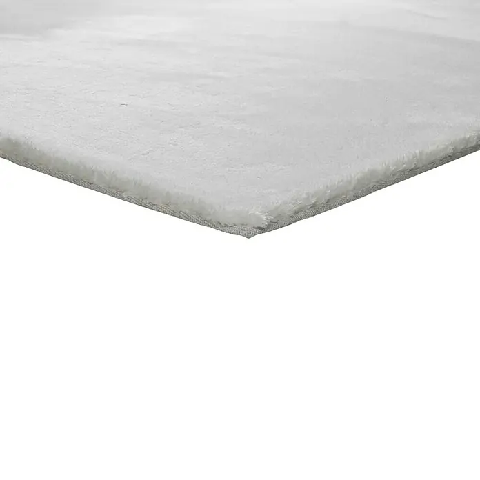 Alfombra de pelo corto Kristel - Blanco, 110 x 60 cm, 100% Poliéster - Primer plano de una alfombra blanca con superficie suave y borde limpio, perfecta para añadir calidez a cualquier hogar.