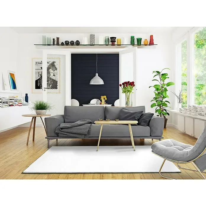 Alfombra de pelo corto Kristel - Blanco, 110 x 60 cm, 100% Poliéster - Sala de estar con sofá gris, mesa de centro y alfombra. Accesorios decorativos y plantas crean un ambiente acogedor.