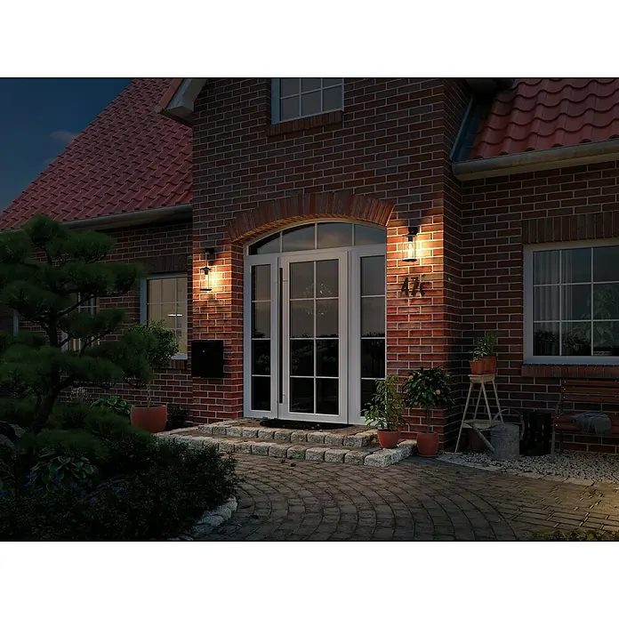 Paulmann LED-Lampe Vintage 1879 Filament - E27, Dimmbar, Warmweiß, 470 lm, 6 W, 1 Stk. - Eine Nahaufnahme einer Wandleuchte an einer Backsteinfassade, die warmes Licht ausstrahlt und eine einladende Atmosphäre schafft.