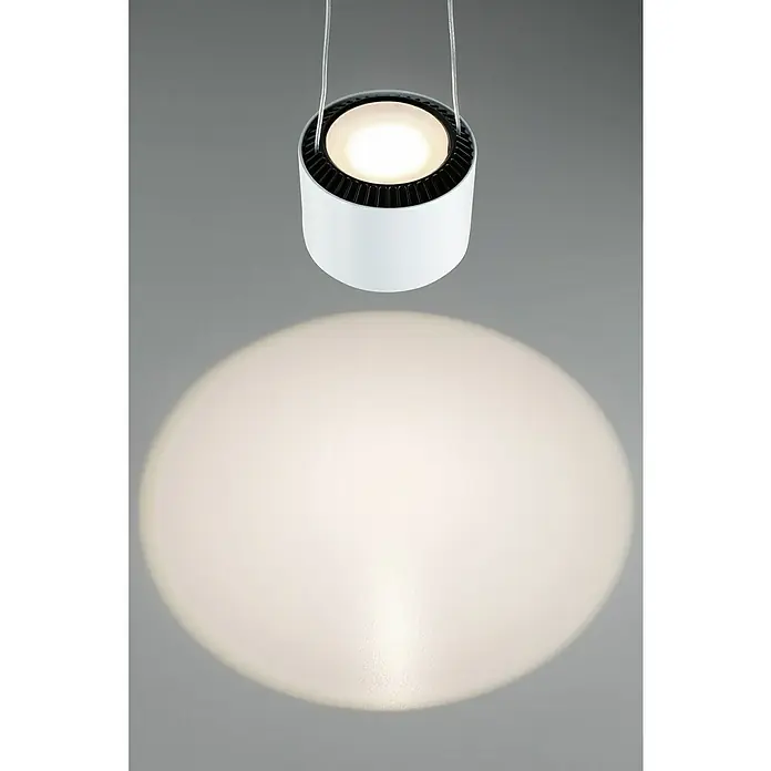Paulmann URail LED-Pendelleuchte Aldan - Neutralweiß, Signalweiß, Ø x H: 9,8 x 150 cm, 4.000 K - Hängeleuchte: Moderne, zylinderförmige Hängeleuchte in Weiß und Schwarz, die ein helles, kreisförmiges Licht auf eine graue Oberfläche wirft.