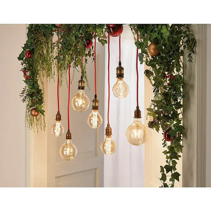 Paulmann LED-Lampe Vintage 1879 Filament - E27, Dimmbar, Warmweiß, 450 lm, 6 W, 1 Stk. - Festliche Dekoration mit hängenden Glühbirnen, roten Kabeln und winterlichen Girlanden, die eine warme, einladende Atmosphäre schaffen.