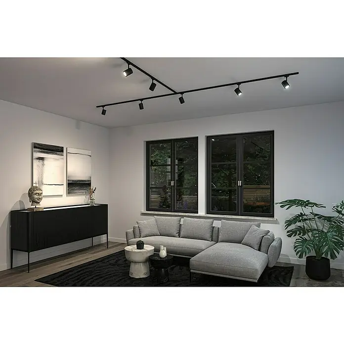 Paulmann URail LED-Spot Luxe - 10 W, Schwarz matt, 6,5 x 9 x 16,3 cm, RGBW - Moderne Wohnzimmeransicht mit schwarzer Schrankwand, grauem Sofa, Teppich und auffälliger schwarzer Deckenbeleuchtung.