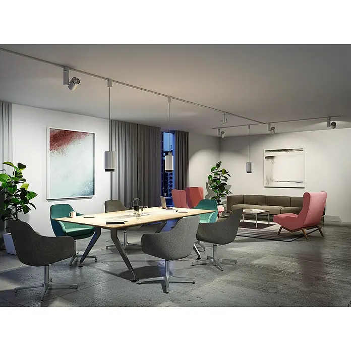 Paulmann URail LED-Spot ZeuzChrom matt, 9,8 x 17,6 x 26 cm, 2.770 lm, Warmweiß - Ein Konferenzraum mit einem Holztisch und farbigen Stühlen, beleuchtet durch eine moderne Schienenbeleuchtung an der Decke. Stilvolles Ambiente für Besprechungen.